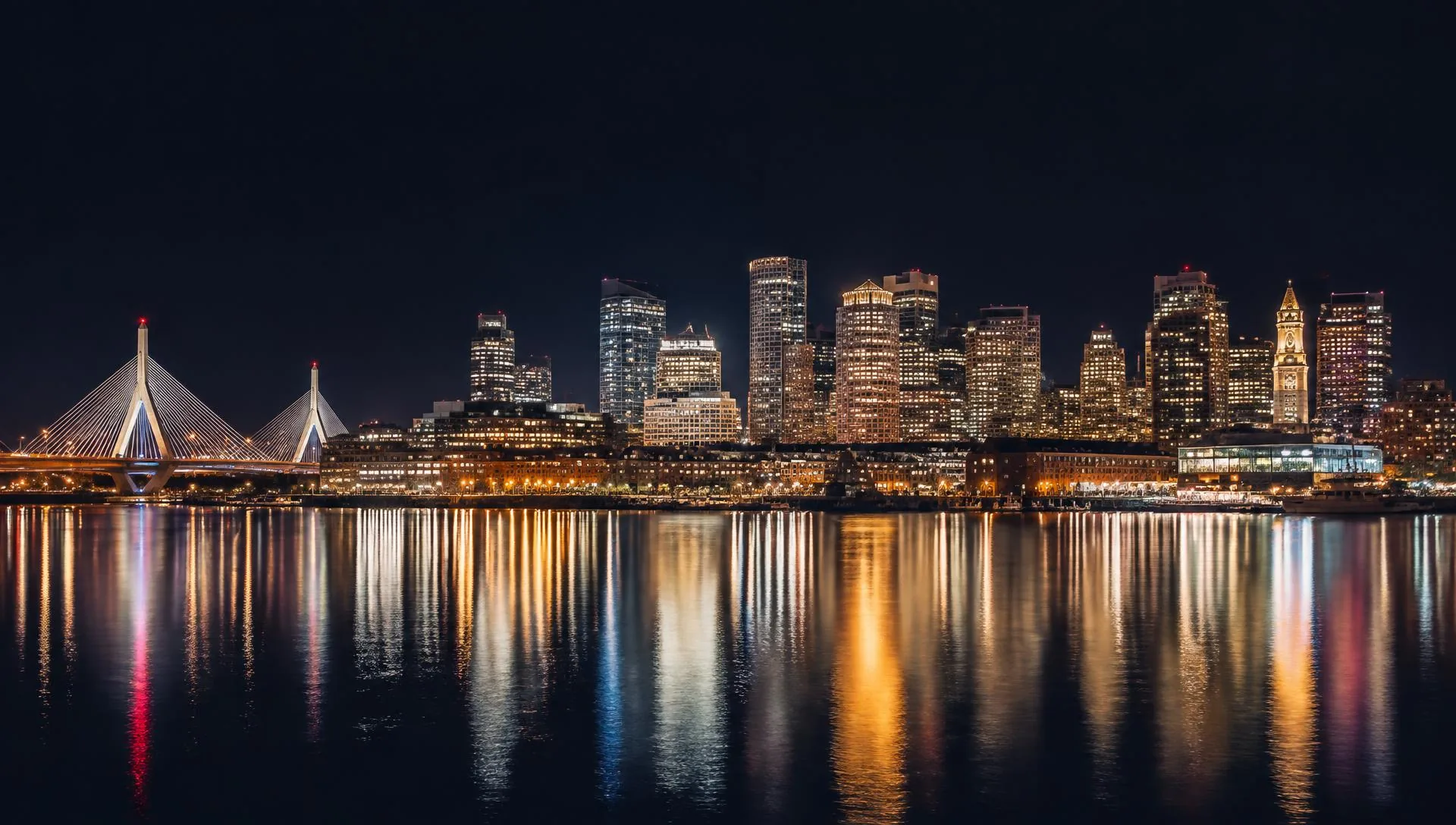 Boston skyline illuminated at night across the harbor